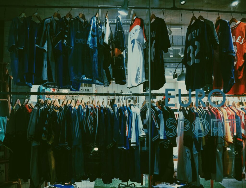 A variety of football jerseys on display in a Tokyo clothing store, highlighting a vibrant shopping scene.