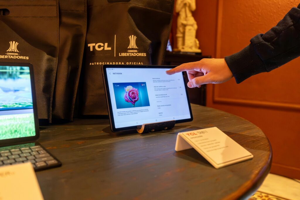 Close-up of a person using a touchscreen tablet during a tech conference, highlighting modern connectivity.